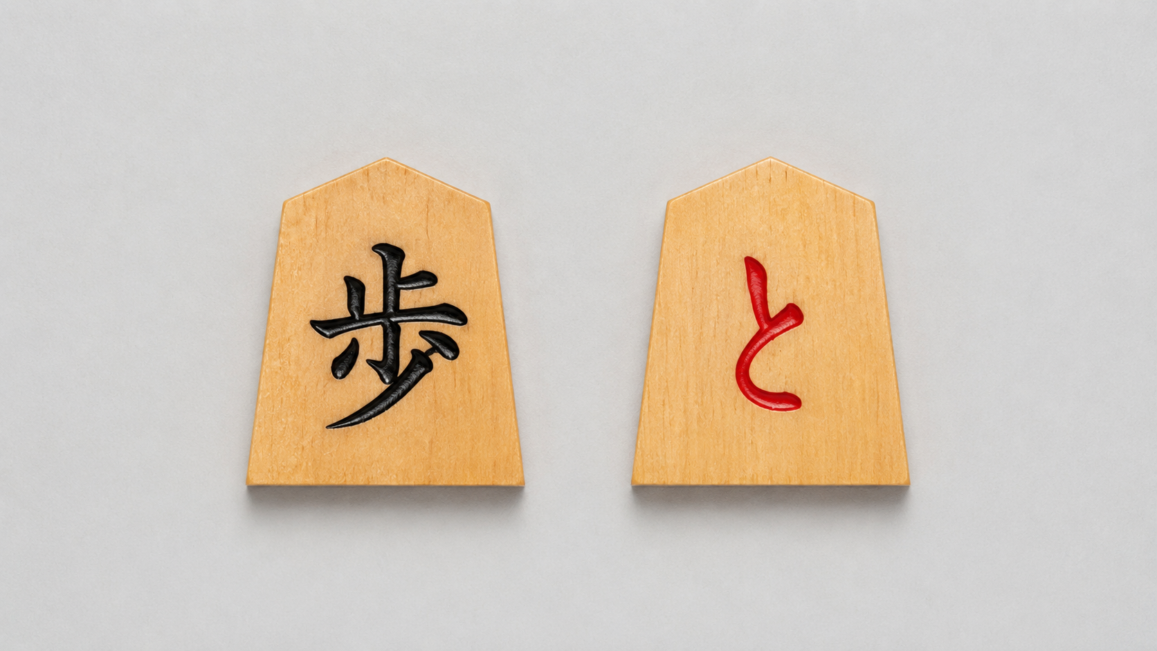 Two faces of a shogi pawn: fu (歩) on the left, tokin (と) on the right