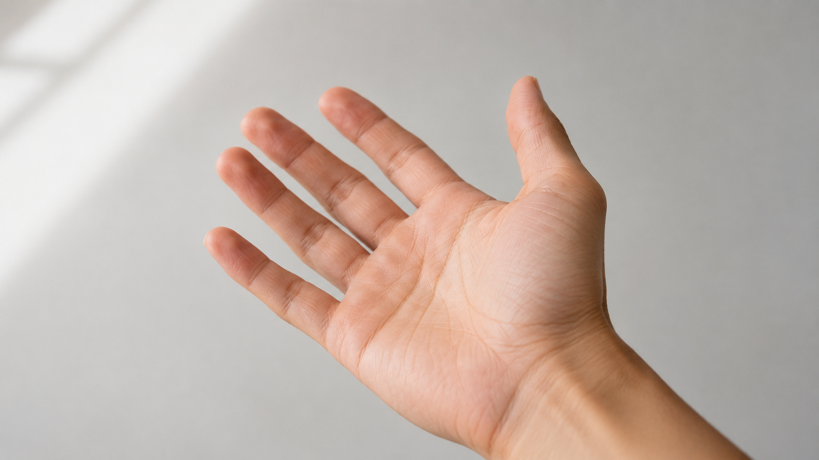 An open, relaxed hand ready to begin a coin flip