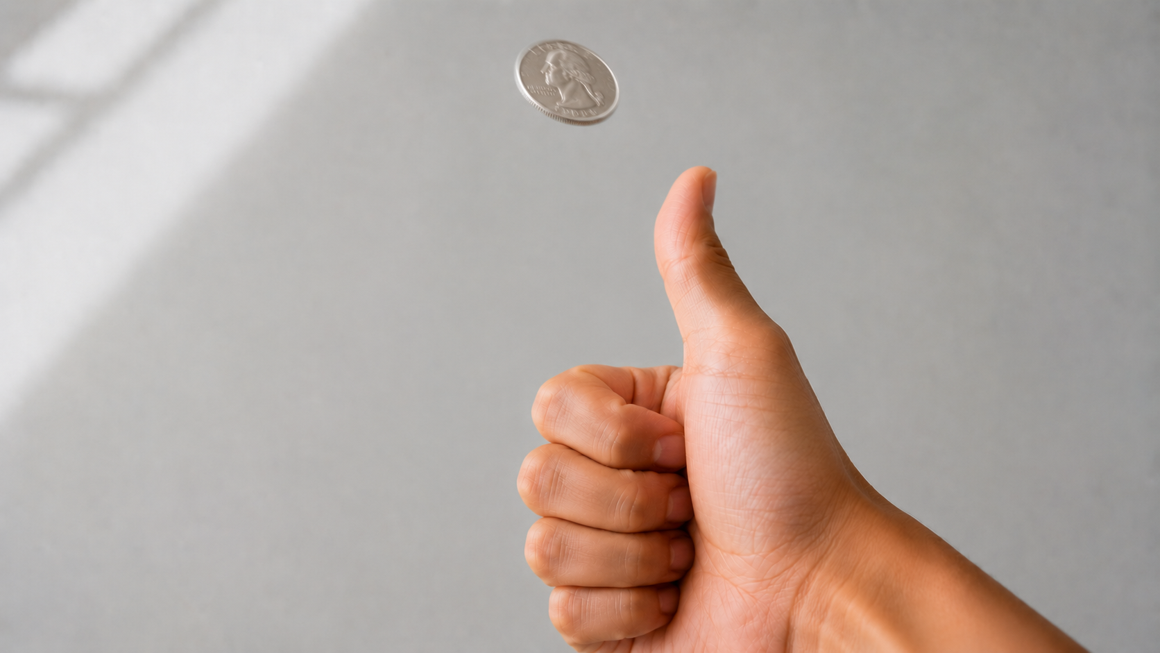 A silver coin held by the thumb just before being flicked into the air